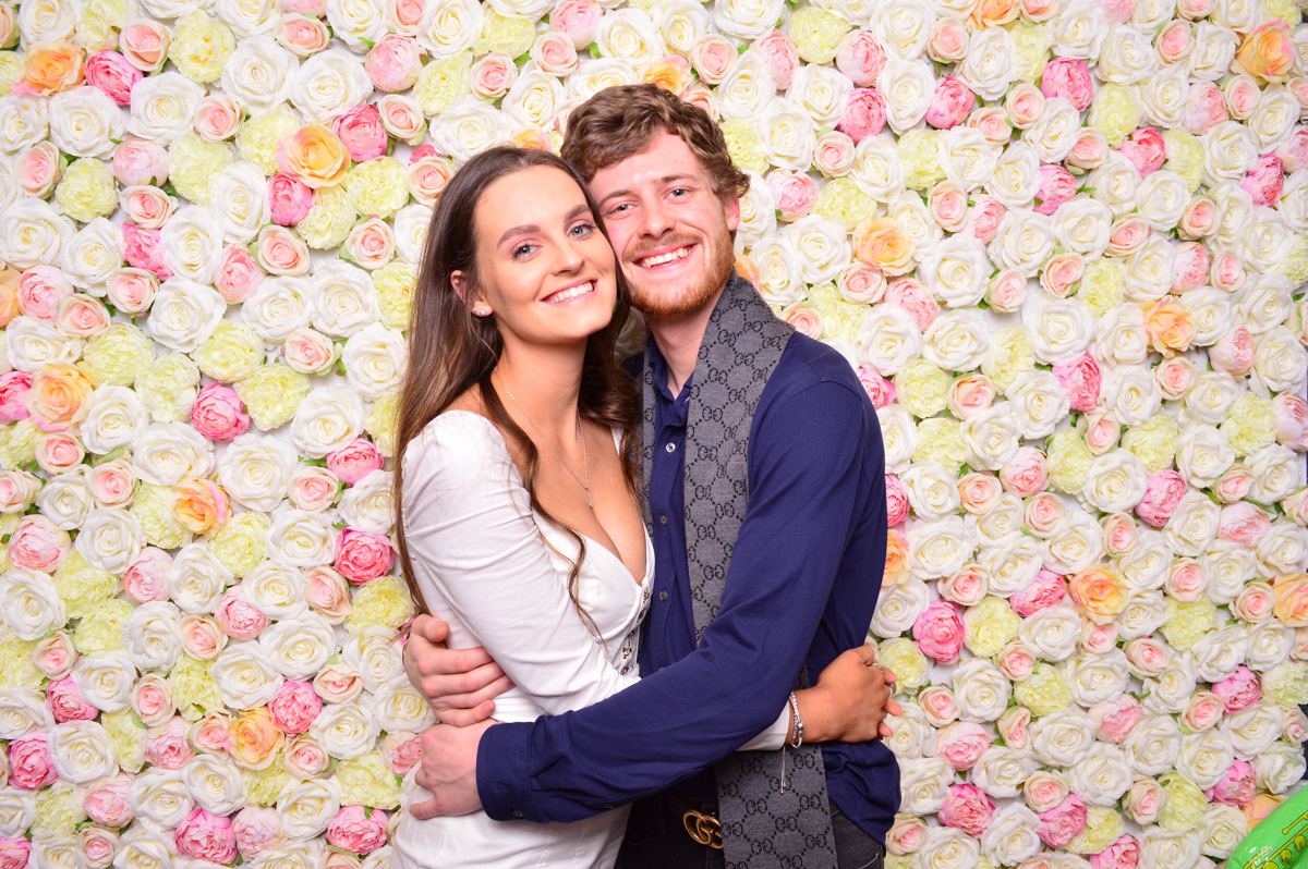 Wedding guests posing against the Bubble flower wall photo booth
